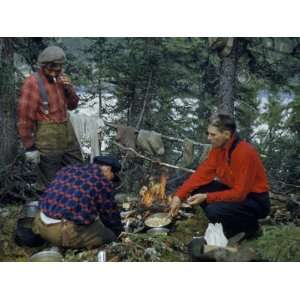  Men Huddle by Campfire as it Cooks their Food and Dries 