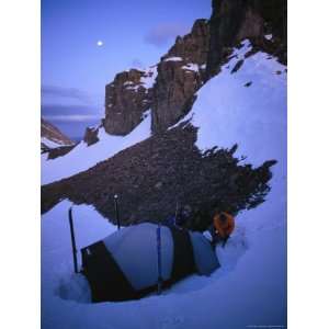  A Man Sets up Camp at Moonrise in a Snowy Mountain 